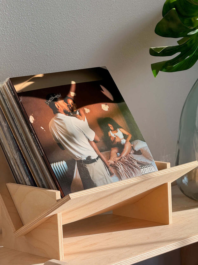 Stylish wood book and vinyl record holder displaying a music album in a modern home setting.