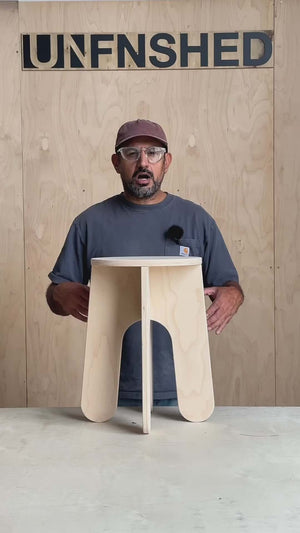 Person demonstrating the No Tool Stool, a versatile unfinished stool that requires no tools for assembly.