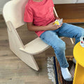 A child playing cards while sitting on a Mini Rocker kids rocking chair, showcasing fun and relaxation.