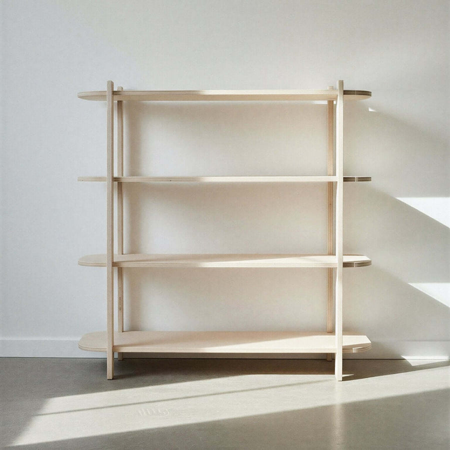 Four level wooden bookshelf against a white wall with sunlight casting shadows on the floor.