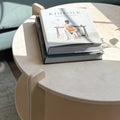 28-inch round coffee table showcasing books and a natural wood finish, perfect for stylish living room decor.