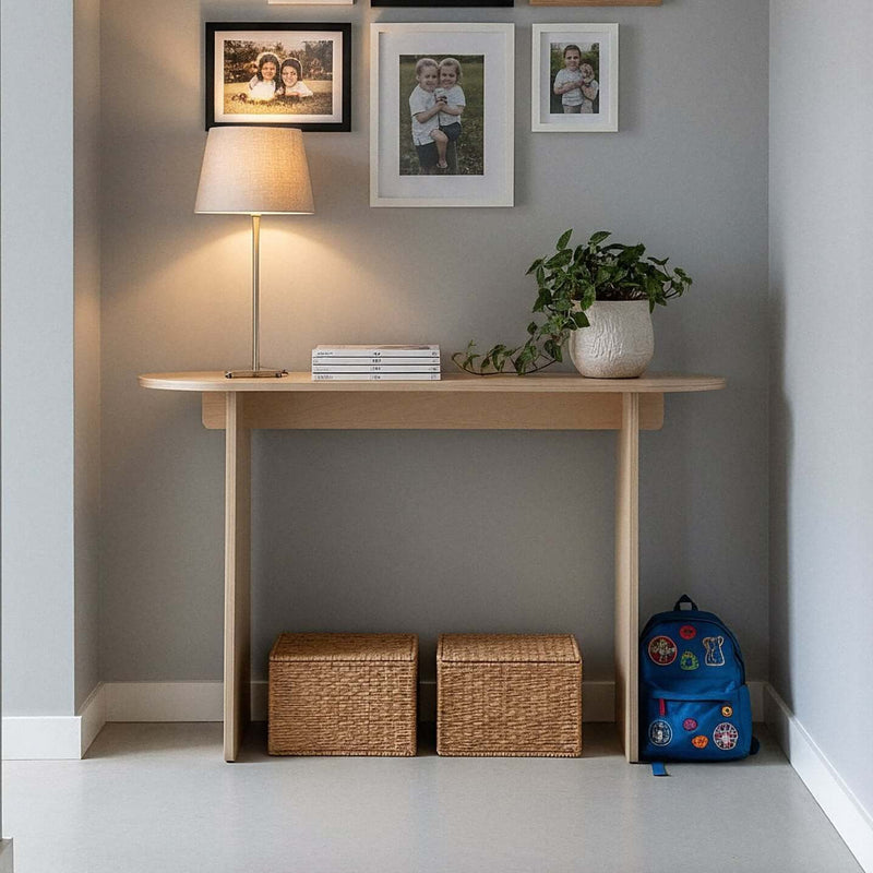Modern Console Table under a gallery wall with a lamp and plant, baskets and a backpack underneath