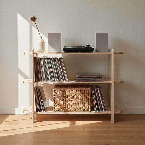 Wooden shelf with records and a basket against a white wall