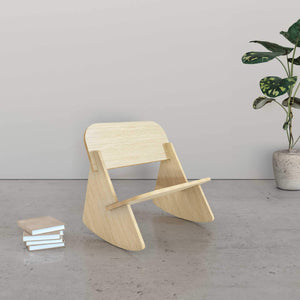 Mini Rocker kids rocking chair in a minimalist room with books and a plant.