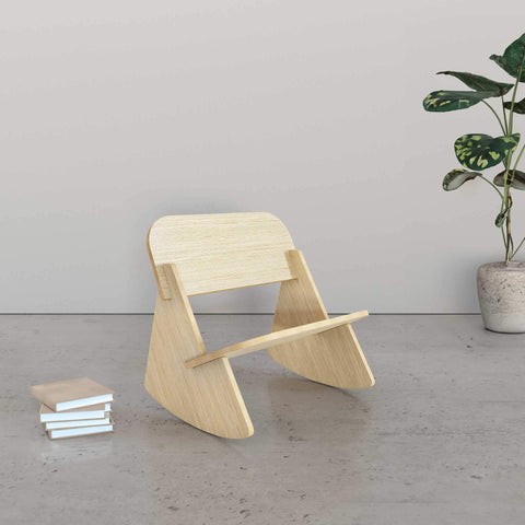 Mini Rocker kids rocking chair in a minimalist room with books and a plant.