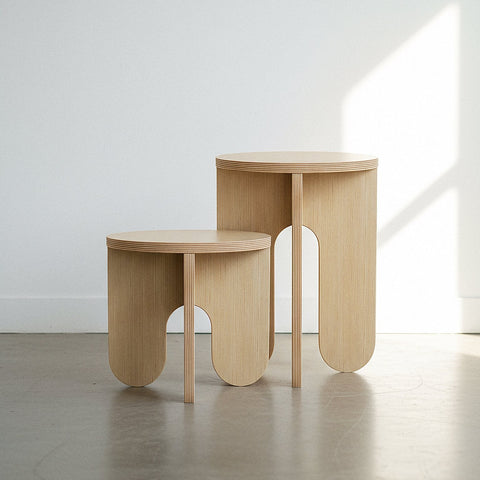 Two modern wooden side tables with unique designs, showcasing natural textures and a light finish.