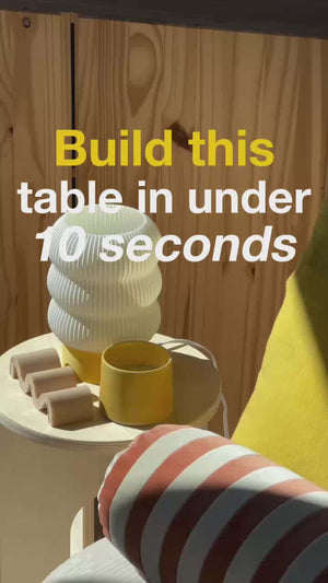 Unfinished side table with decorative objects, highlighting easy assembly in under 10 seconds.